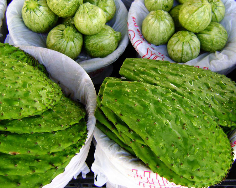 Fresh, green cacti pads without prickly leaves, in paper-wrapped bowls